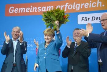 Merkel celebra la victoria en la sede de su partido levantando un ramo de flores. (Foto: E)