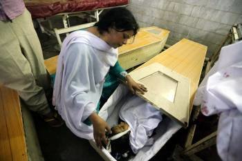 Una mujer observa el cadáver de una niña en un ataud. (Foto: B. ARBAB)