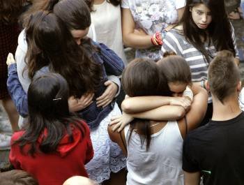 Compañeras de la menor asesinada se abrazan en el instituto Rosalía de Castro, de Santiago. (Foto: XOÁN REY)