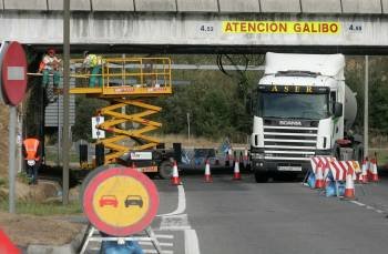 Un camión circula entre las vallas instaladas, mientras los trabajadores revisan las vigas del puente. (Foto: MARCOS ATRIO)