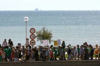Los manifestantes de Cases de Alcanar con la plataforma del almacén de gas en el horizonte. (Foto: J SELLART J)