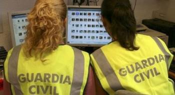 Dos mujeres de la Guardia Civil investigan un delito informático.
