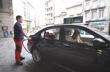 El trabajador de una estación de servicio de la ciudad suministra combustible a un turismo. (Foto: MARTIÑO PINAL)