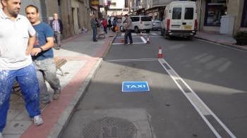 Operarios municipales pintando los nuevos espacios para los taxis en la calle Laureano Peláez.
