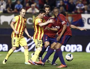 Messi se empotra contra tres defensores del Osasuna. (Foto: JESÚS DIGES)