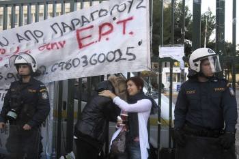 Dos trabajadoras de la televisión pública griega, entre dos agentes ante la sede del canal público (Foto: SIMELA PANTZARTZI)