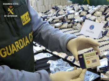 Un guardia civil sostiene una caja de Viagra falsificada.