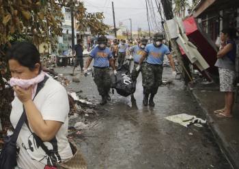Un grupo de militares traslada cadáveres por las calles de Tacloban, en la provincia de Leyte. (Foto: FRANCIS R. MALASIG)