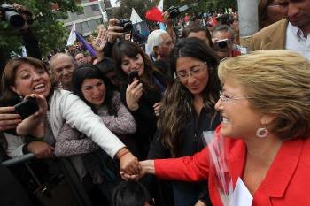 Bachelet saluda a vecinos de un barrio de Santiago, al reaunudar su campaña electoral ayer. (Foto: MARIO RUIZ)