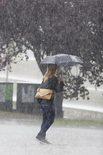 Una joven pasa por el Campus en un día de lluvia. (Foto: XESÚS FARIÑAS)