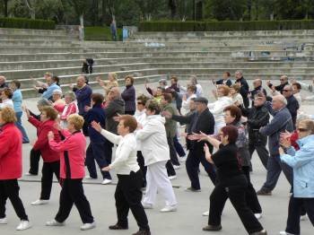 Un grupo de personas mayores realiza ejercicios en un parque. 