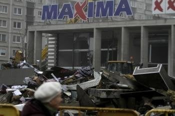 Una mujer pasa por delante del centro comercial que se desplomó. (Foto: Valda Kalnina)