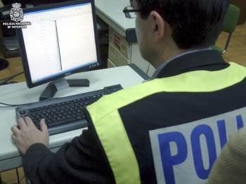 Un policia de la brigada de delitos informáticos, con un ordenador incautado en una operación.