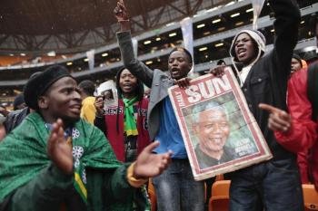 Una multitud de sudafricanos canta y baila bajo la lluvia mientras ocupa el estadio FNB de Soweto