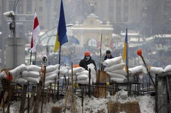 Dos opositores, encaramados a una barricada en Kiev. (Foto: ZURAB KURSIKIDZE)