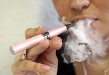 Una mujer fuma un cigarrillo electrónico, cuyo uso en lugares públicos se prohibió ayer.
