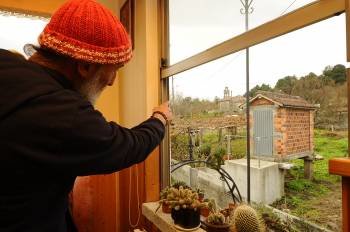 Juan Ruiz muestra desde la ventana de su casa el campanario de la iglesia. (Foto: MARTIÑO PINAL)