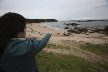Una mujer señala el lugar de la playa de A Pobra en donde fue localizado el cadáver. (Foto: SXENICK)