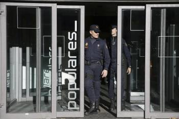Dos agentes, en las puertas de la sede durante el registro.