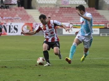 El lateral ourensanista Pinillos intenta impedir la progresión de un jugador de la SD Logroñés. (Foto: FERNANDO DÍAZ)