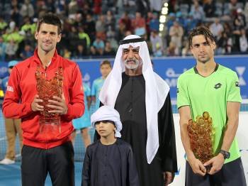 Novak Djokovic y David Ferrer, con sus trofeos, junto al ministro de Cultura de los Emiratos Árabes y un joven. (Foto: ALI HAIDER)
