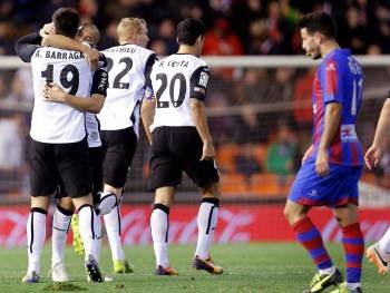Los jugadores del Valencia celebran el segundo gol sobre el Levante. (Foto: J.C. CÁRDENAS)