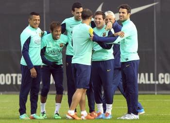 Mascherano, Busquets y Fábregas abrazan a Messi en un entreno. (Foto: ANDREU DALMAU)