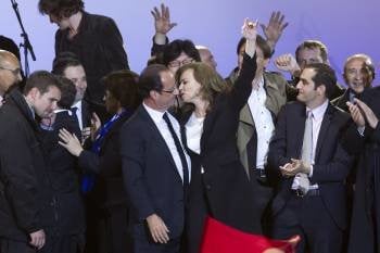 Hollande besa a su pareja en la última noche electoral desarrollada en Francia.  (Foto: IAN LANGDON)