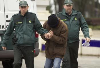 El acusado llega a los juzgados de Lugo custodiado por dos agentes de la Guardia Civil.  (Foto: ELISEO TRIGO)