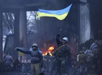 Un opositor ondea una bandera ucraniana en una de las barricadas levantadas en Kiev. (Foto: MAXIM SHIPENKOV)