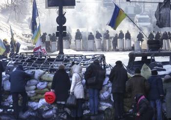 Un grupo de opositores observa a los agentes en Kiev. (Foto: MAXIM SHIPENKOV)