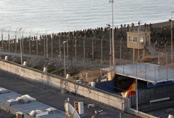 Cientos de inmigrantes, en la valla de separación de Ceuta.  (Foto: REDUAN)