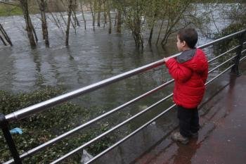 Un niño observa ayer el caudal del río Miño a su paso por Ourense.  (Foto: Miguel Ángel)