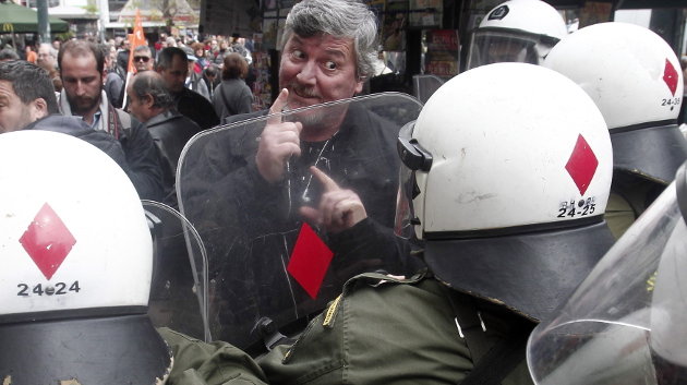 Un manifestante gesticula ante los agentes antidisturbios a la entrada del Ministerio de Finanzas, en Atenas.