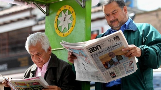 Dos personas leen una de las publicaciones gratuitas que ya cerró