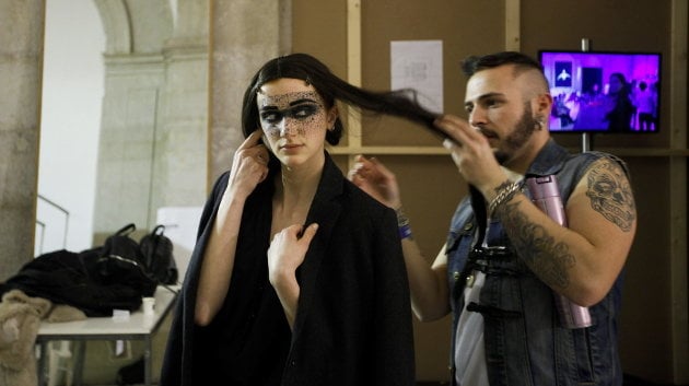 Una modelo es peinada antes de desfilar en la semana de la moda de Lisboa