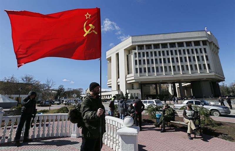 Un ciudadano crimeo sostiene una bandera soviética cerca del Parlamento crimeo