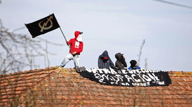 Activistas de la plataforma Stop Desahucios en un tejado de un inmueble del barrio coruñés de Palave