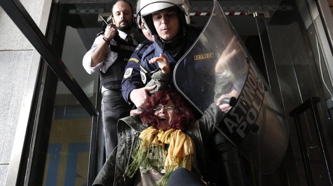 Agentes de policía sacan a la fuerza a una trabajadora que se manifestaba contra los recortes