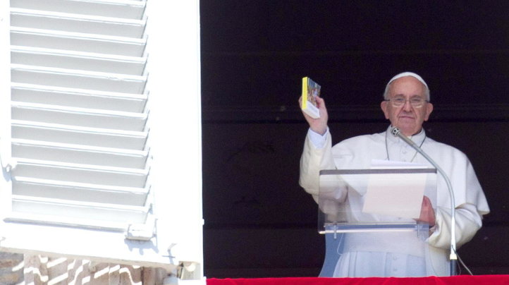 El Papa Francisco sostiene una de los evangeliso pequeños que ha repartido entre los fieles
