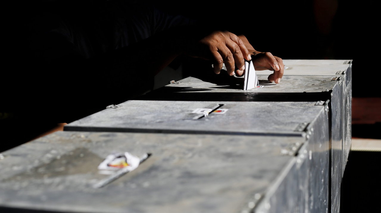 Un hombre ejece su derecho al voto en un colegio electoral en Denpasar
