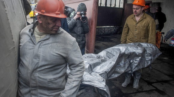Miembros de los servicios de rescate trasladan el cuerpo de uno de los mineros 