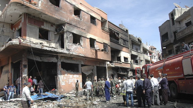 Agentes de policía sirios inspeccionan el lugar donde ha explosionado un coche bomba en Homs