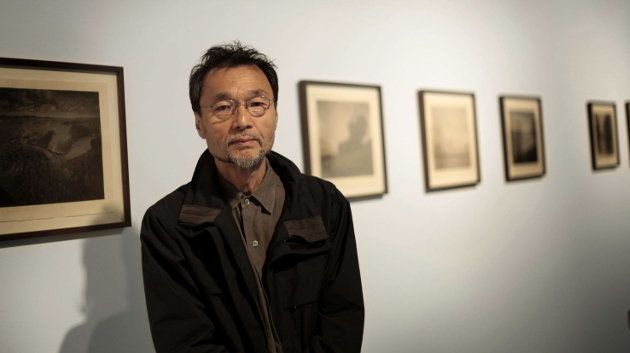 El fotógrafo japonés Takeshi Shikamal posa ante algunas de sus obras durante la inauguración de la exposición &#34;Los murmullos del bosque&#34;