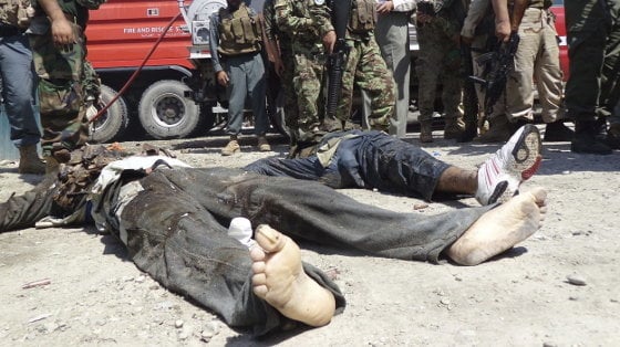 Agentes de seguridad afganos observan el cadáver de un talibán que participó en un asalto a la sede del departamento de Justicia en Jalalabad