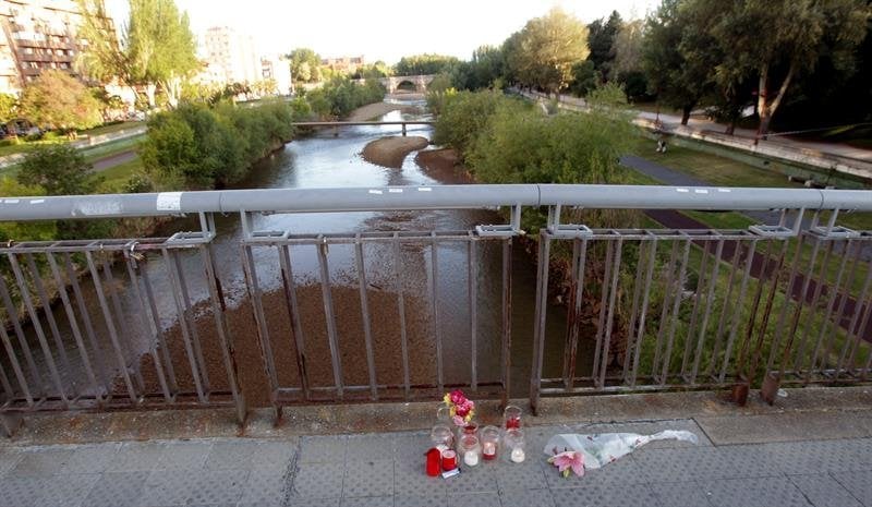 Un ramo de flores y varias velas recuerdan a Isabel Carrasco, en el lugar en el que ayer fue abatida a tiros por una mujer, una pasarela sobre el río Bernesga que comunica el Paseo de la Condesa con la Avenida de Salamanca
