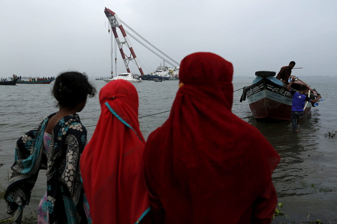 Varios familiares supervisan las operaciones de rescate del barco MV Miraj 4 en el río Megna cerca de Munshiganj 