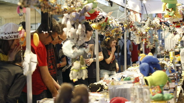 Varios visitantes observan los productos expuestos en uno de los estands de Expomanga 2014