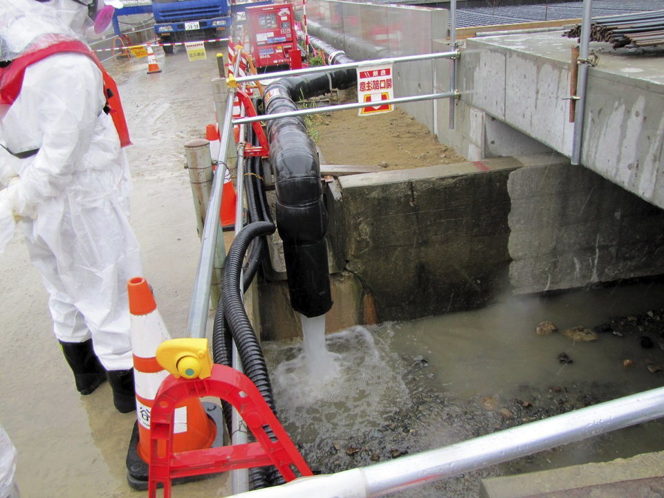 Un trabajador de Tokyo Electric Power (TEPCO) junto a un desagüe durante el vertido controlado al mar de agua
