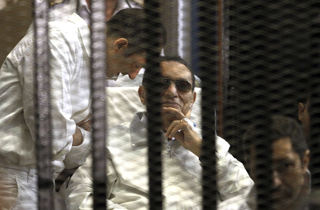 Foto de archivo de Gamal Mubarak (izq) y su hermano Alaa (dcha) junto a su padre el expresidente egipcio Hosni Mubarak (c) en una celda de la sala del tribunal durante su juicio
